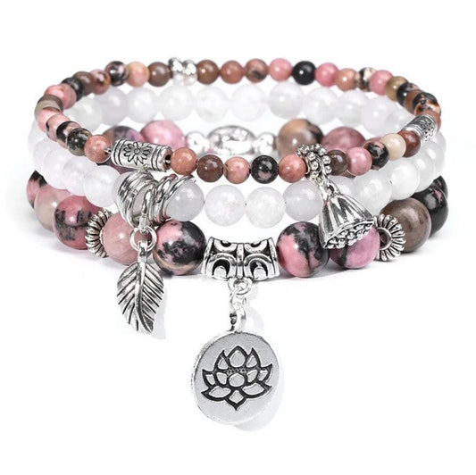 Stack of beaded bracelets with charms on a white background