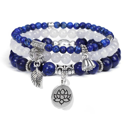 Set of blue and white beaded bracelets with silver charms on a white background