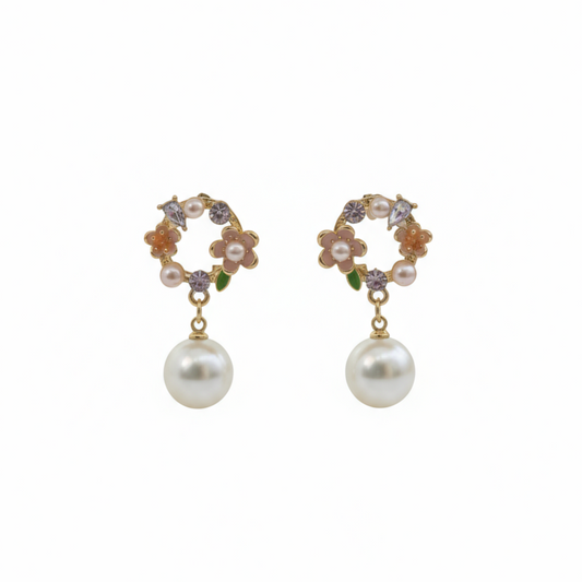 Pair of pearl earrings with floral and gemstone details on a light background