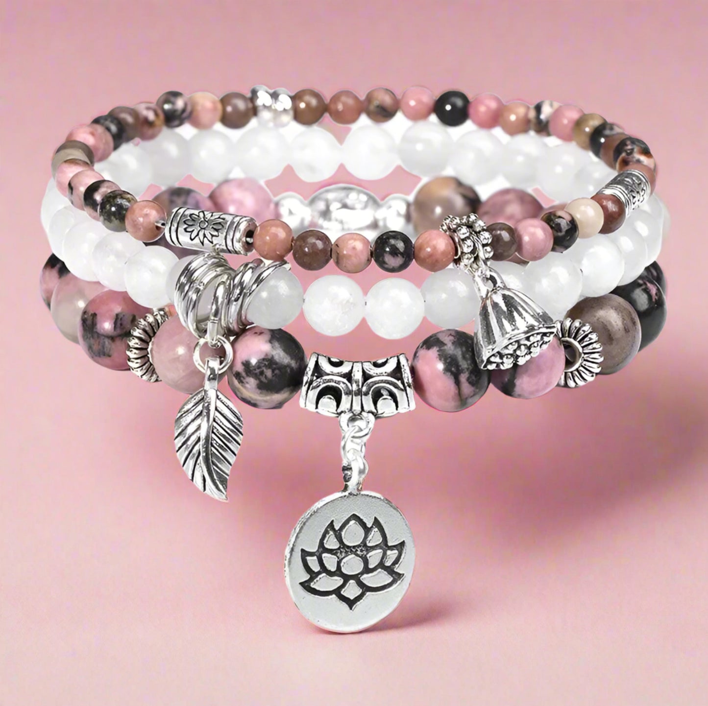Stack of beaded bracelets with charms on a white background