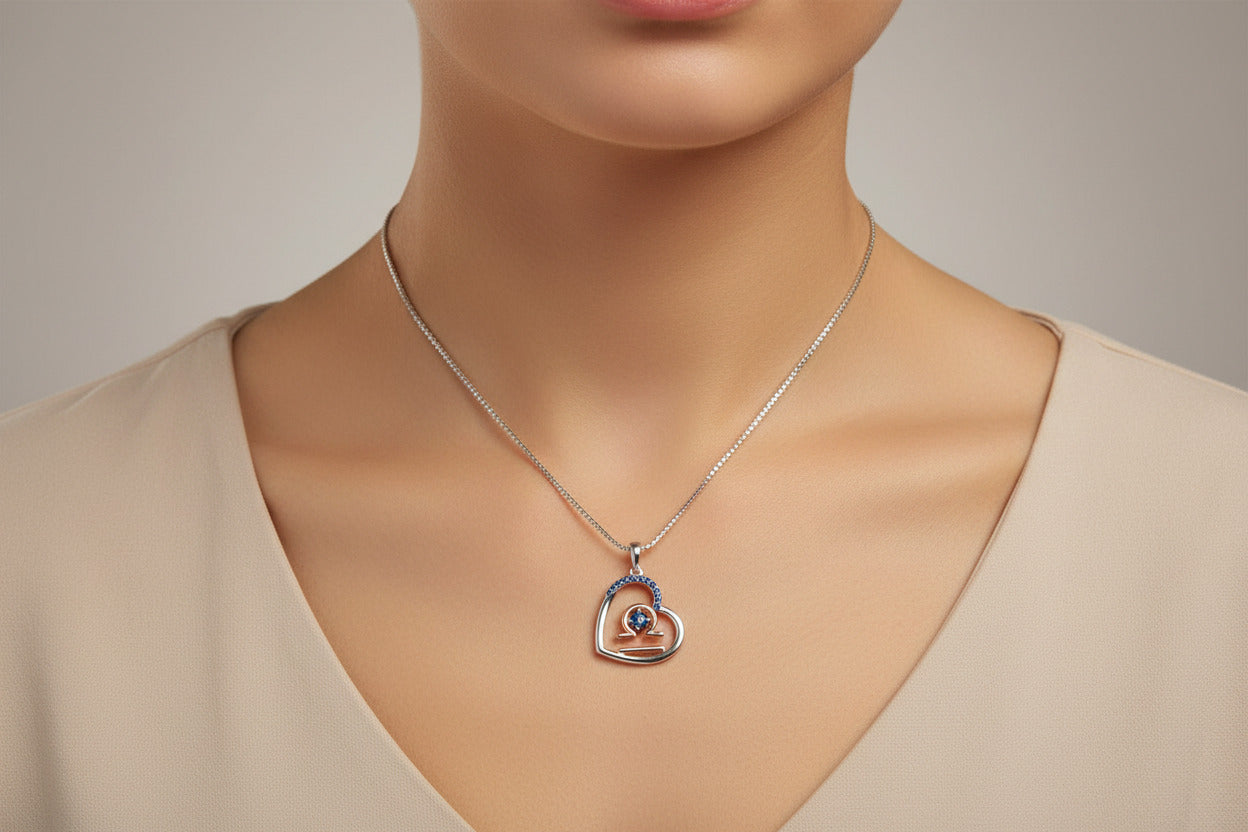 Heart-shaped pendant with blue gemstones on a white background