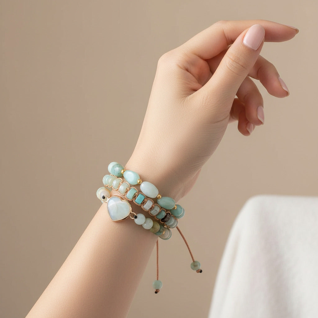 Stack of multicolored beaded bracelets with rose gold accents on a white background