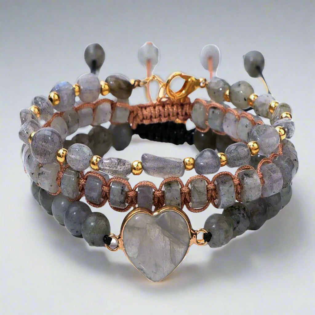 Stack of beaded bracelets with heart-shaped stone on a white background