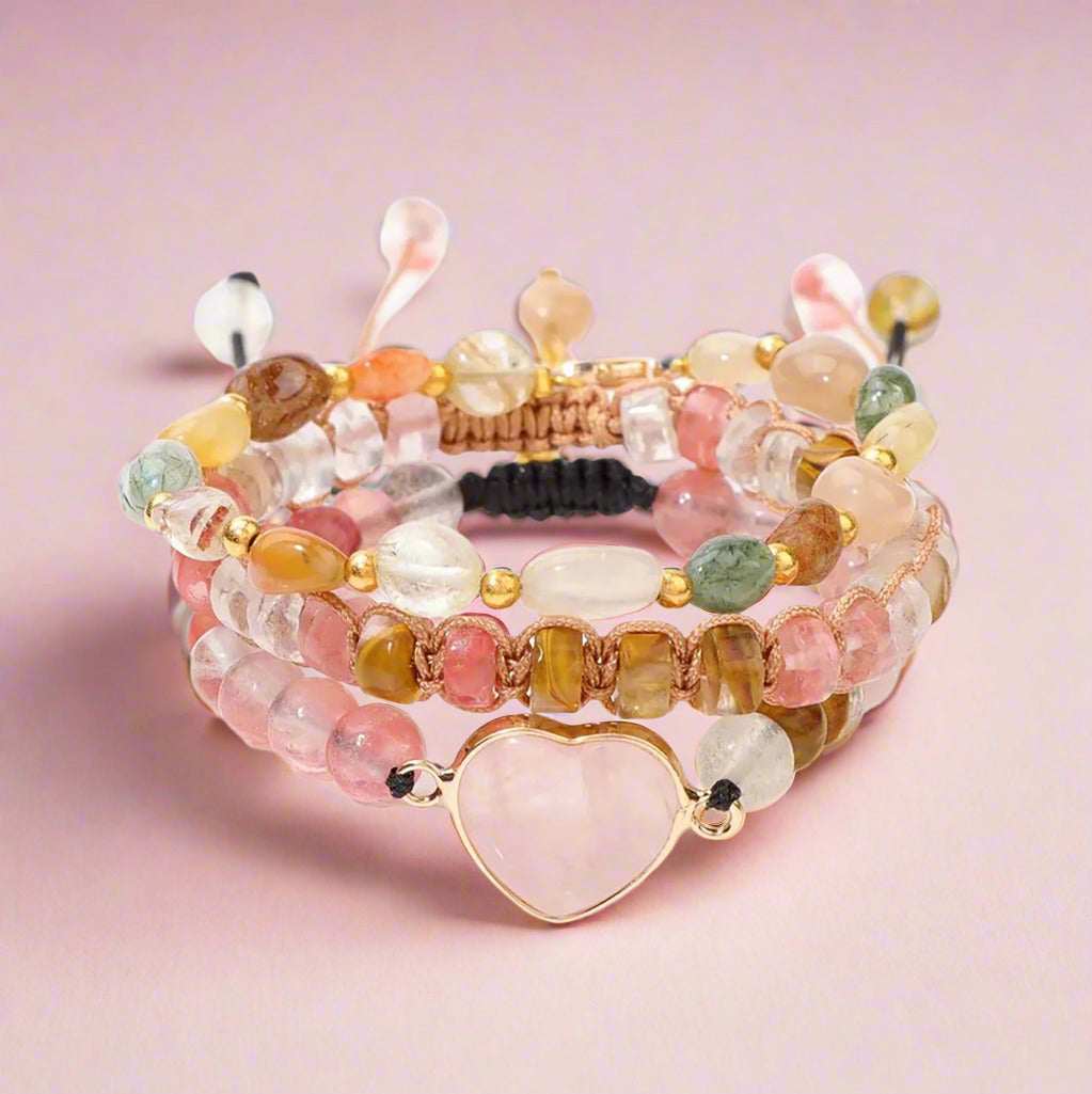 Set of multistrand beaded bracelets with a heart-shaped charm on a white background