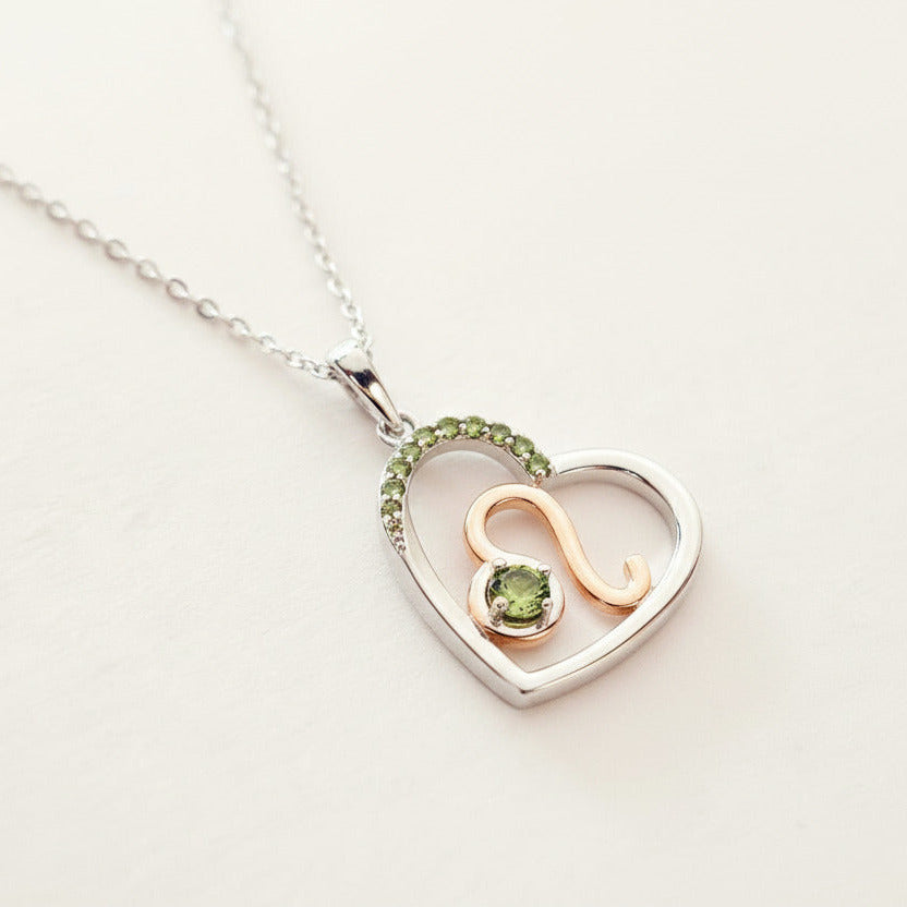 Heart-shaped necklace with a leo zodiac symbol pendant on a white background
