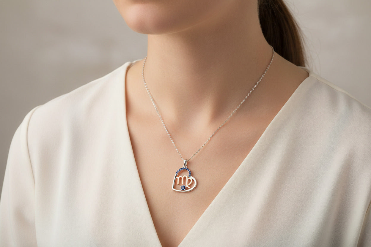 Heart-shaped necklace with 'virgo' zodiac symbol and blue stones on a white background